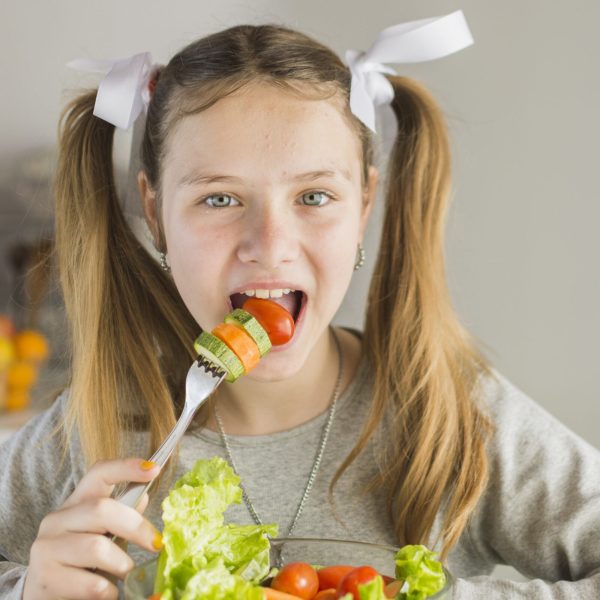 portrait-girl-eating-fresh-vegetable-salad-with-fork