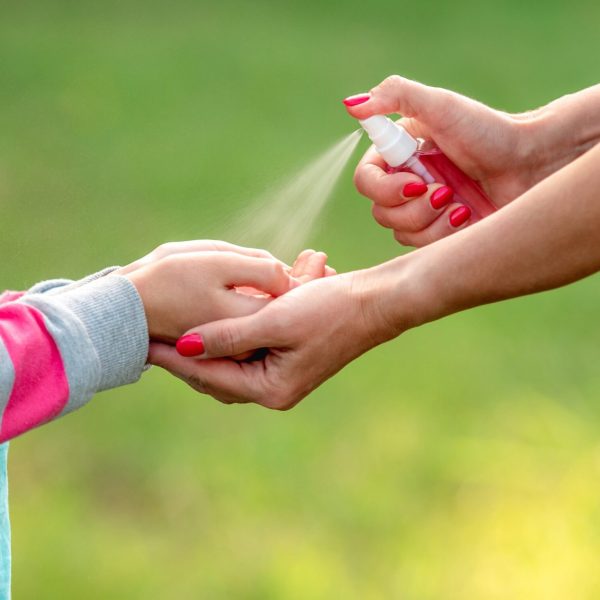 woman-spreading-sanitizer-on-girl-hands-2023-02-02-04-24-51-utc